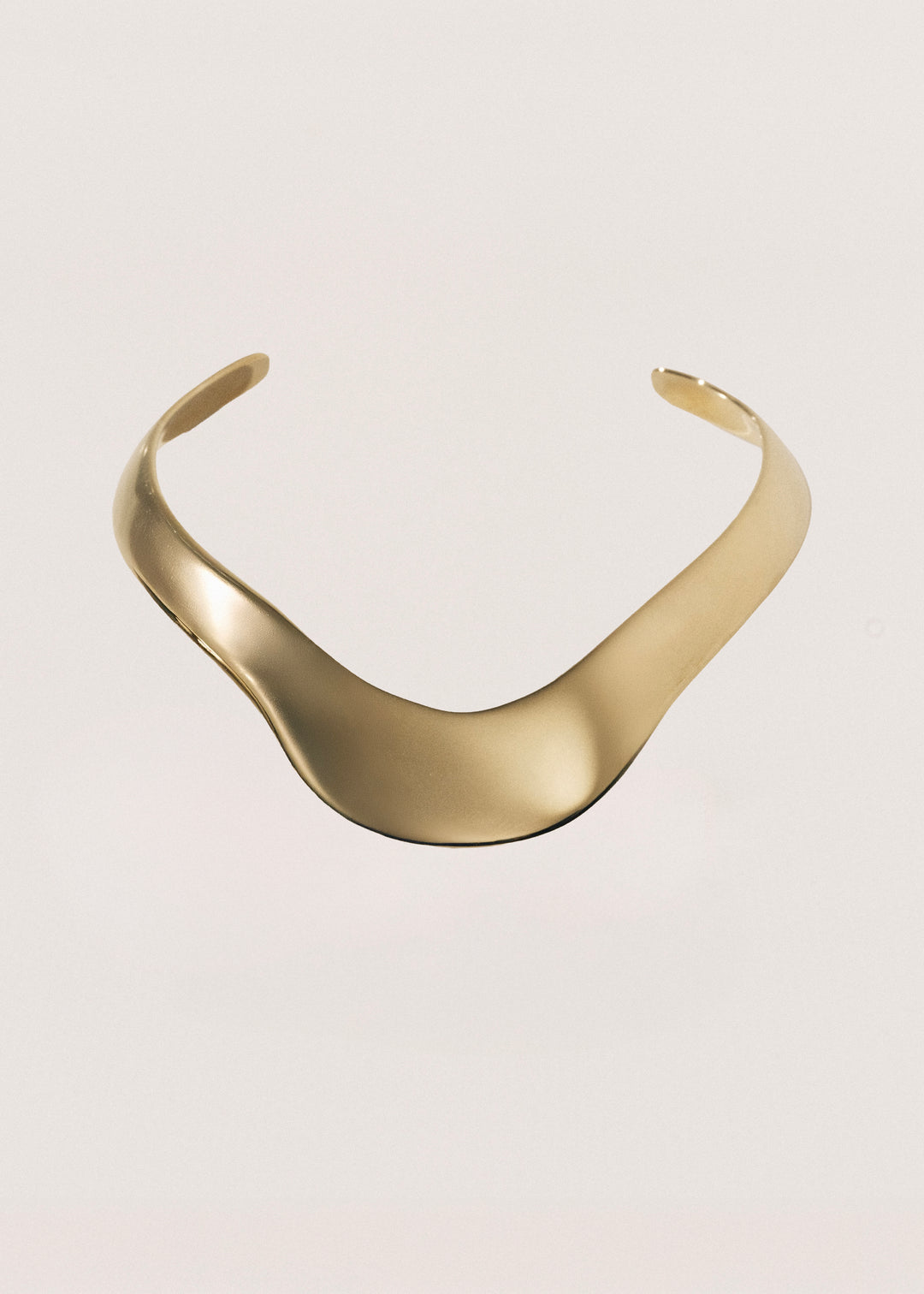Gold choker on a light beige background