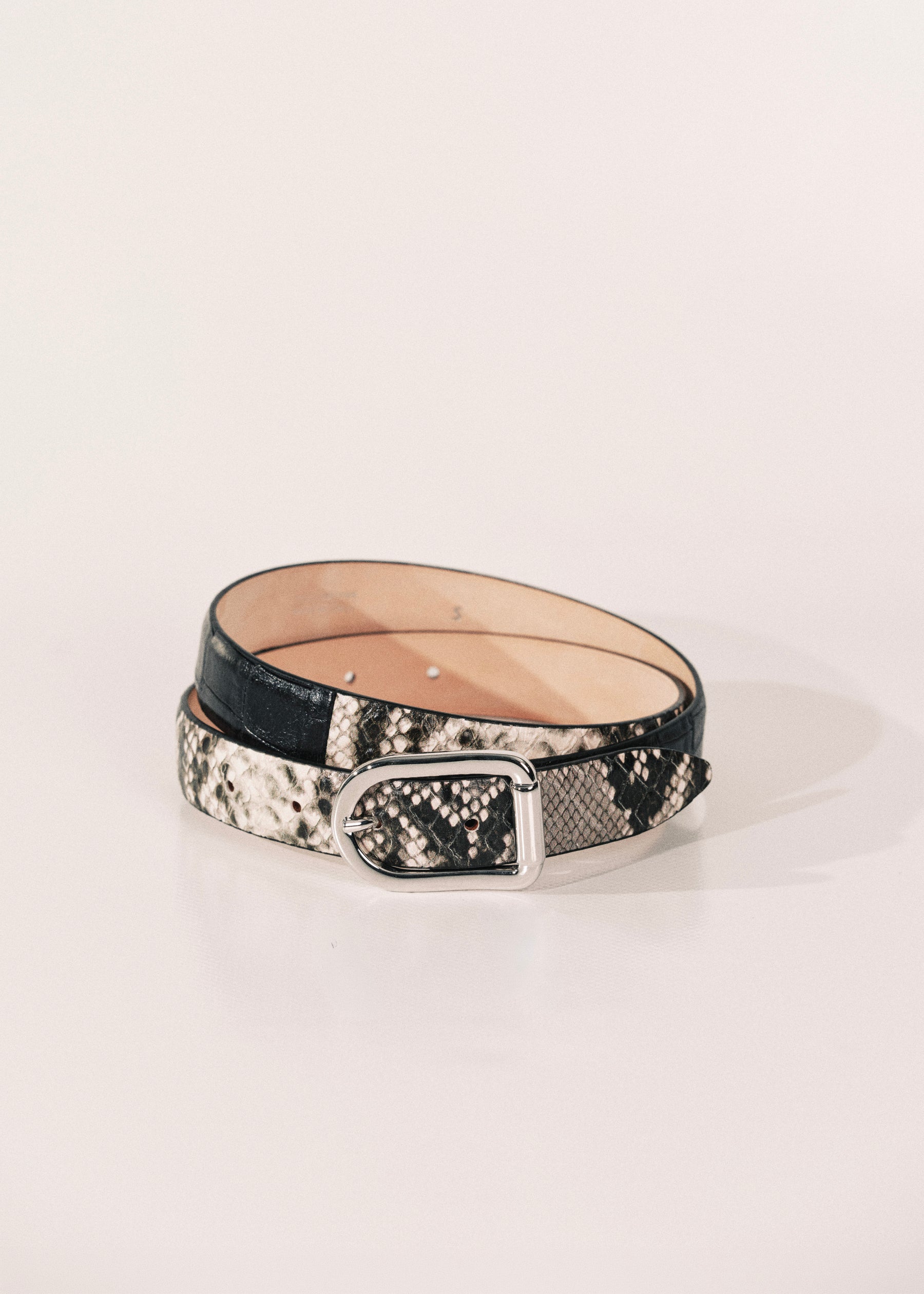 A belt with a black and white snakeskin pattern, a black leather section, and a silver metal buckle.