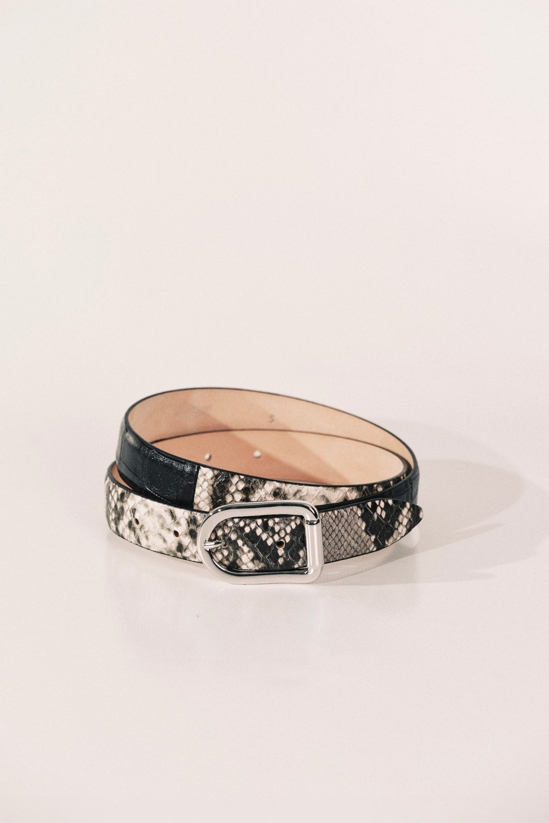 A belt with a black and white snakeskin pattern, a black leather section, and a silver metal buckle.
