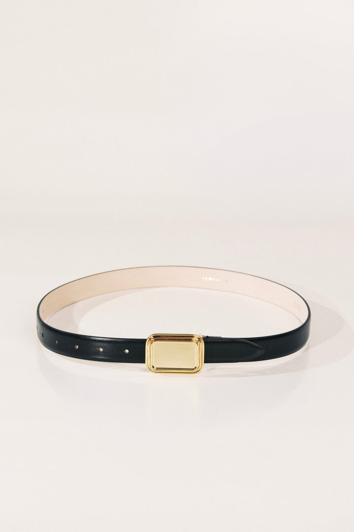 A slim black leather belt with a gold rectangular buckle and a light beige inner lining, displayed on a clean white background.