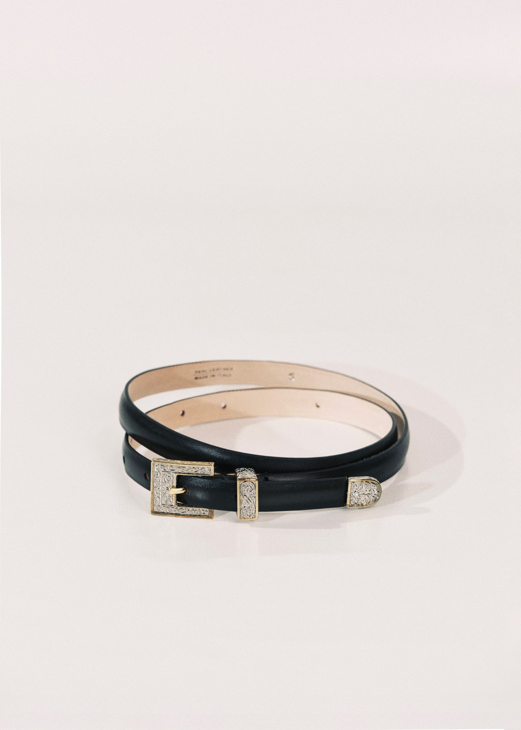 A black leather belt with a silver-tone buckle embellished with clear crystals, displayed on a clean white background.