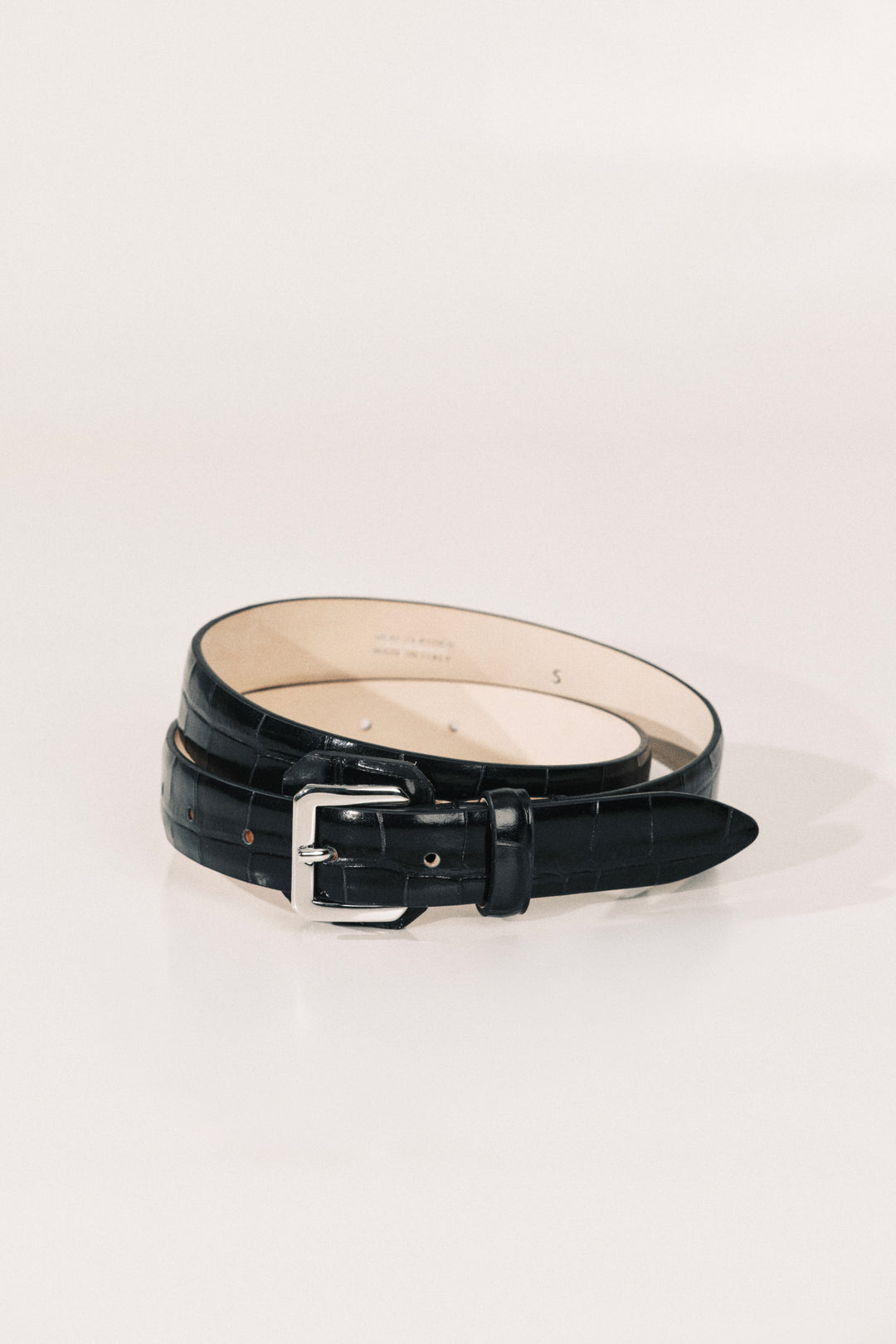 A black alligator belt with a silver-tone buckle. 