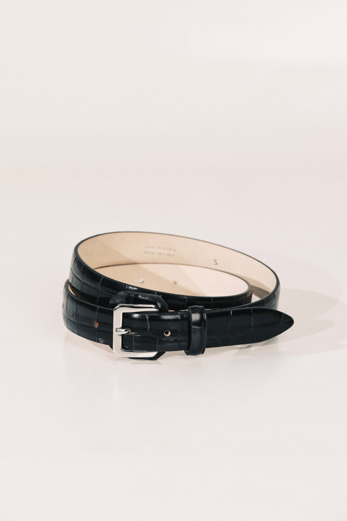 A black alligator belt with a silver-tone buckle. 