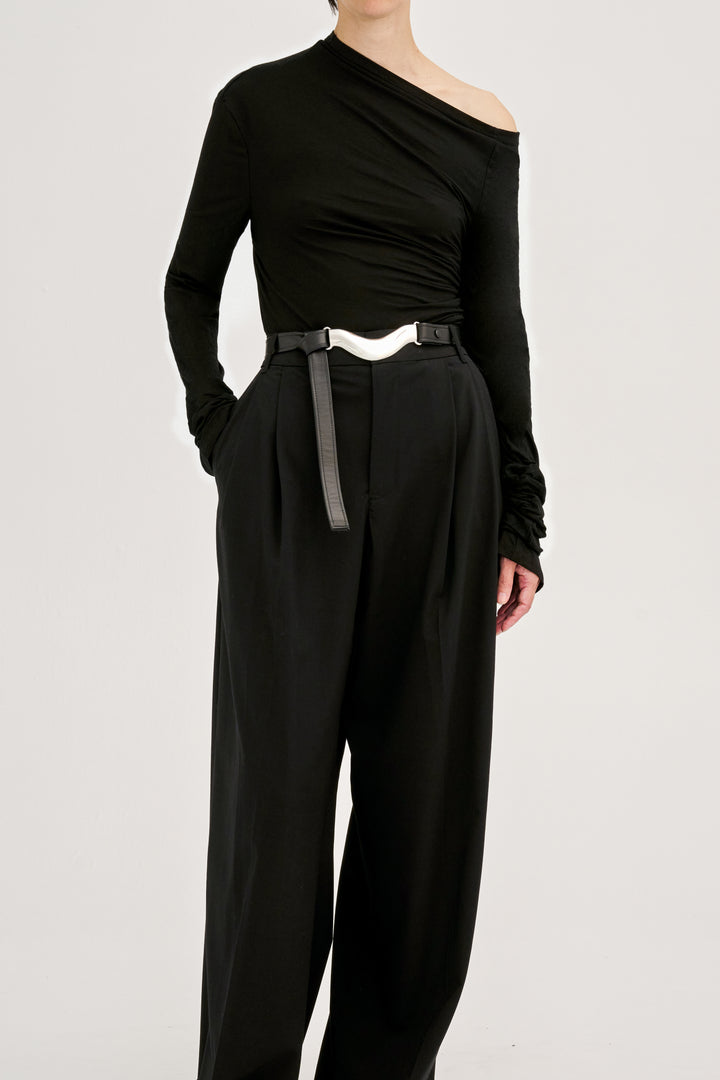 Déhanche brancusi asymmetrical black top and wide-leg pants. Elegant and stylish women's fashion outfit with a silver belt accent. High fashion look.