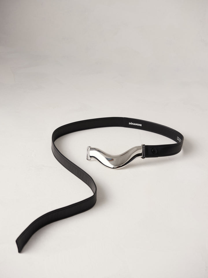 Déhanche Brancusi belt in sleek black leather, featuring a striking sculptural silver centerpiece, epitomizing modern elegance and sophisticated style.