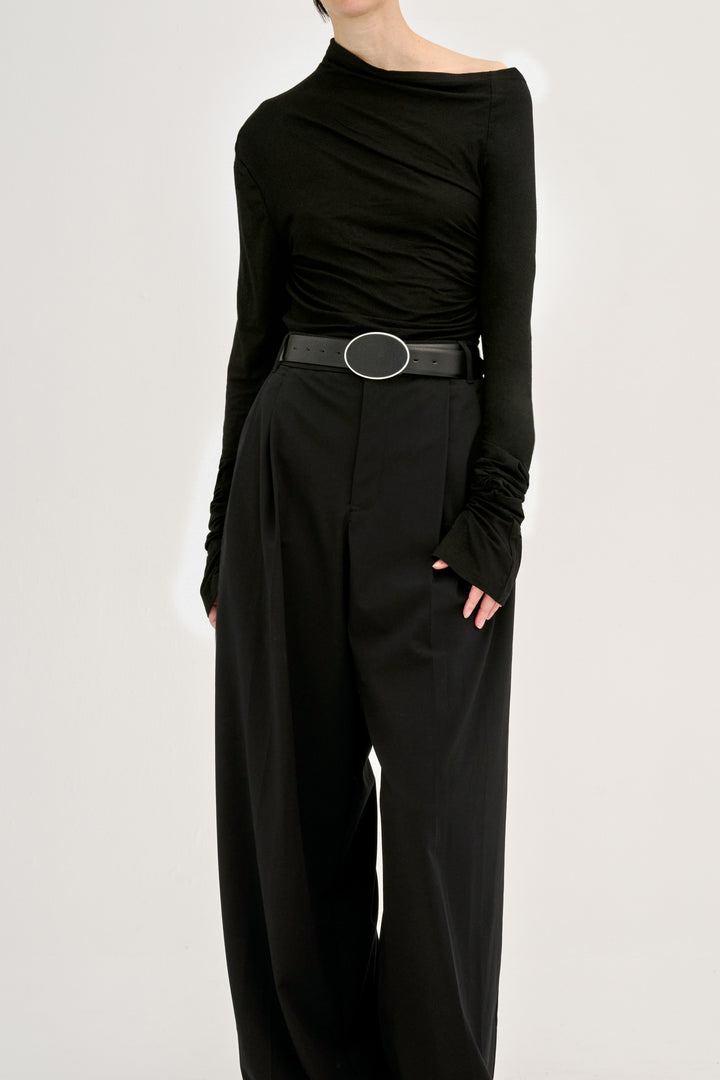 Déhanche flint asymmetrical black top and wide-leg pants. Elegant and stylish women's fashion outfit with a black belt accent. High fashion look.