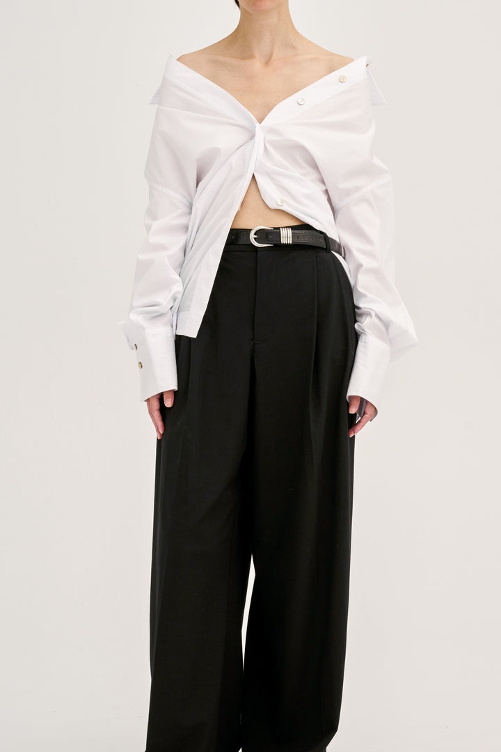 Déhanche hollyhock croco white off-shoulder blouse and black wide-leg pants. Elegant women's fashion outfit with black croco belt accent. High fashion look.