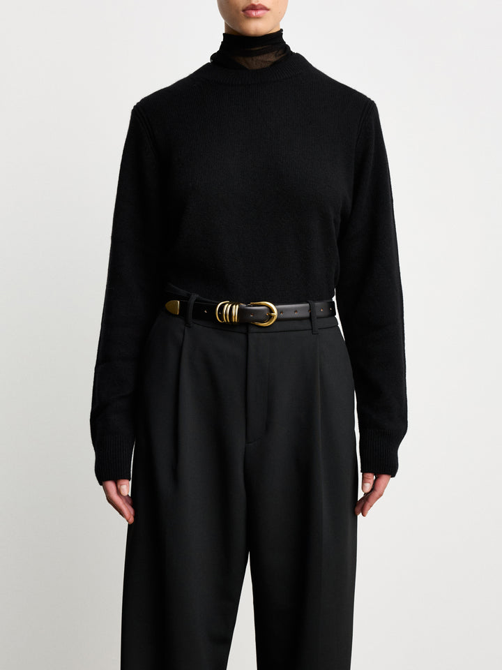 Déhanche Hollyhock Gold Belt - Elegant black leather belt with gold buckle, worn with black high-waisted trousers and a black sweater. Perfect for a refined look.