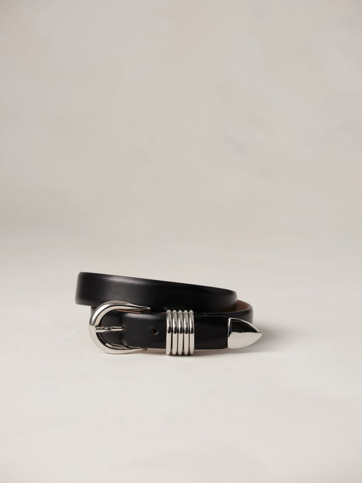 Déhanche Hollyhock belt in sleek black leather, featuring a distinctive silver buckle with intricate detailing, blending classic elegance with modern style.