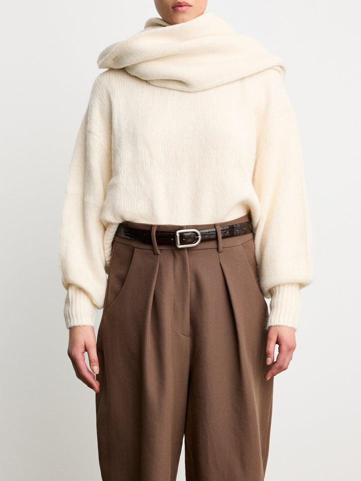 Model wearing Déhanche Mija Croco brown leather belt with crocodile texture and silver buckle, styled with brown trousers and an oversized cream sweater.