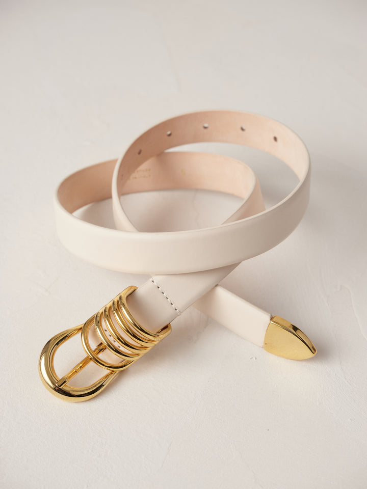 Déhanche Hollyhock Gold Belt - Elegant white leather belt with a gold buckle and accents. Perfect for adding a touch of sophistication to any outfit.
