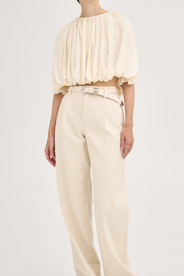Déhanche hollyhock cream puff sleeve blouse and high-waisted pants. Elegant and stylish women's fashion outfit with a white belt accent.
