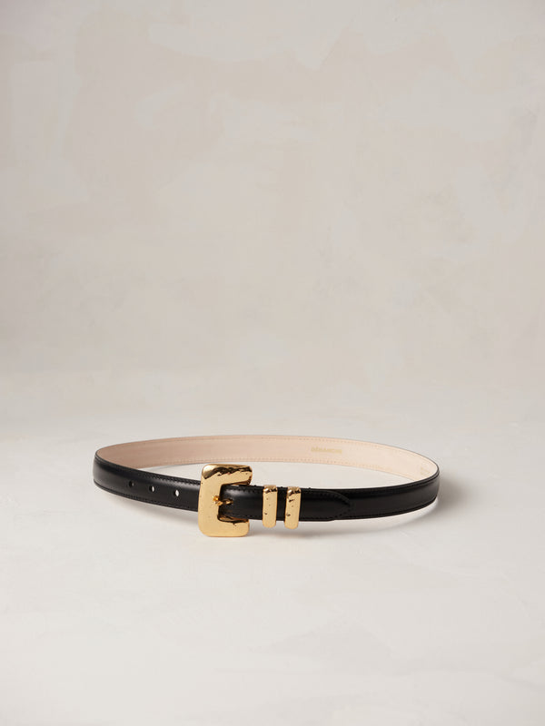 Déhanche tetra belt featuring black leather with a gold buckle and double loops, displayed on a neutral background.