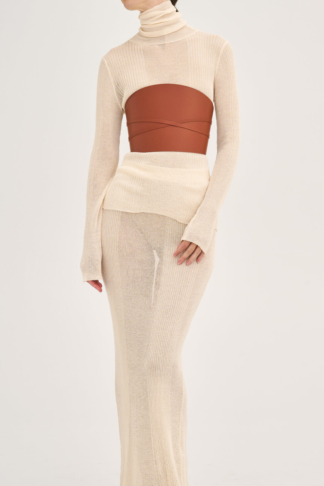 Déhanche Undone Corset in brown leather, styled over a cream knitted dress with long sleeves and high neckline, highlighting a chic front view.