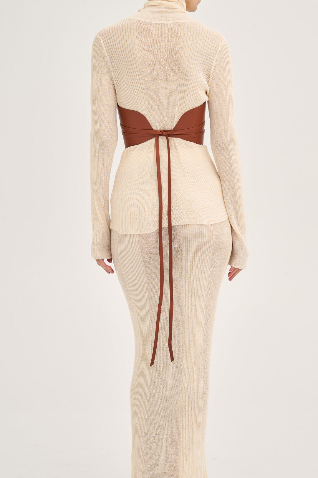 Déhanche Undone Corset in brown leather, paired with a cream knitted dress, showcasing a back view with elegant tie detailing.