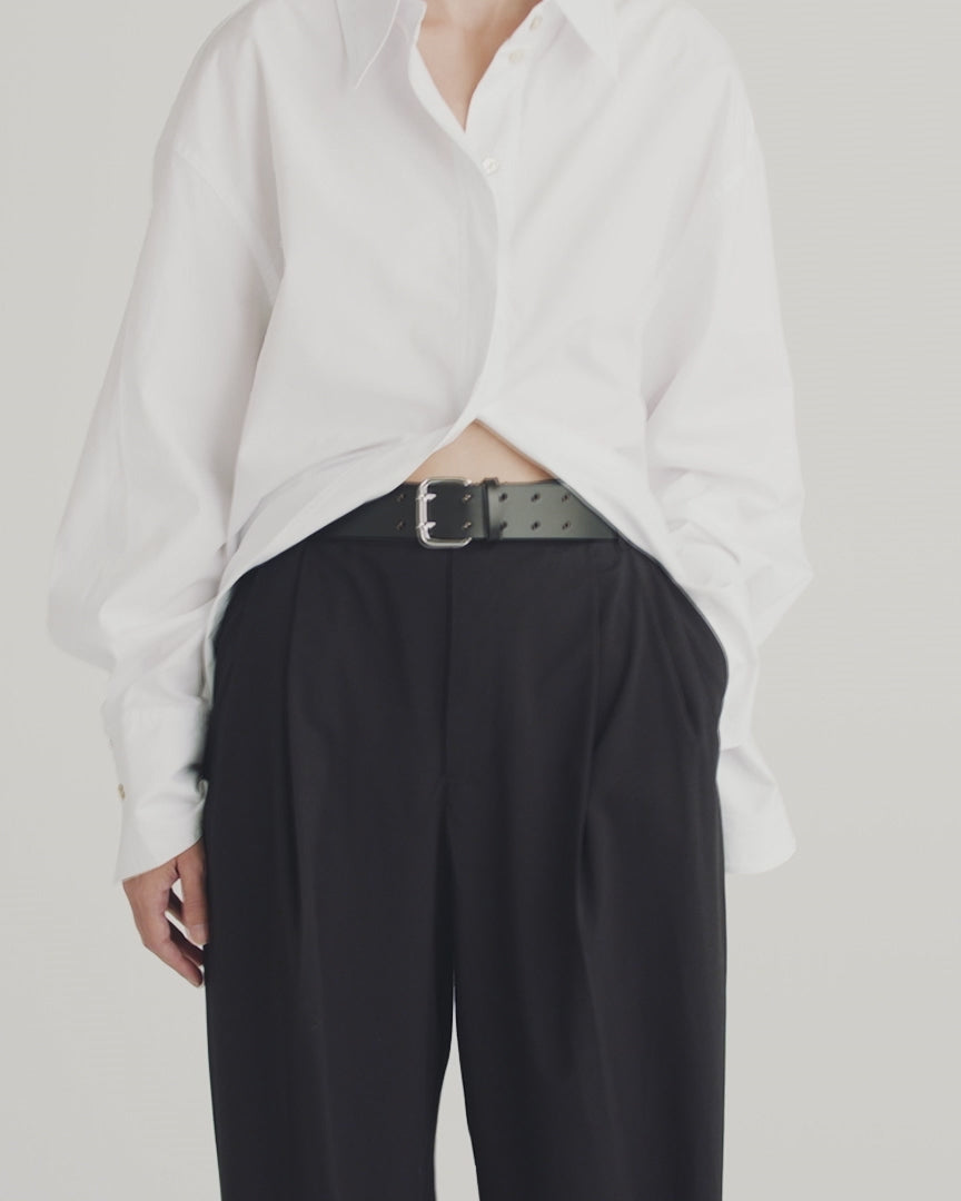Déhanche Hutch Leather Belt - Classic black leather belt with a silver buckle, worn with black trousers and a white shirt. Perfect for a crisp, stylish look.