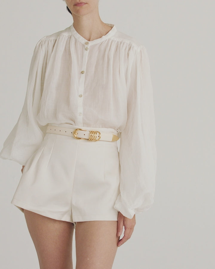 Déhanche Hollyhock Gold Belt - Chic white leather belt with gold buckle, paired with a white blouse and high-waisted shorts. Perfect for a fresh, elegant look.
