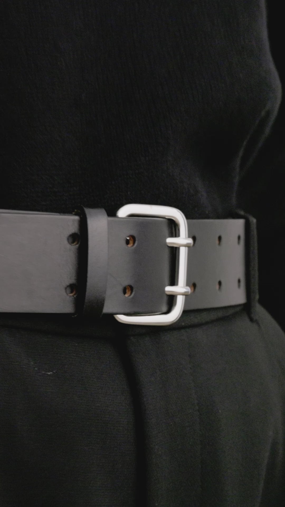 Déhanche Hutch Leather Belt - Classic black leather belt with silver buckle, paired with black trousers and a black sweater. Ideal for a sophisticated, monochromatic look.