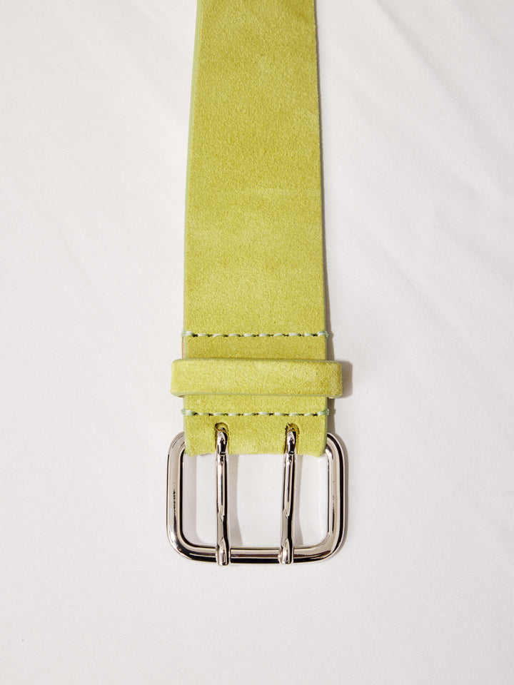 Close-up of Déhanche hutch suede belt in light green with a silver buckle, highlighting the high-quality material and craftsmanship.